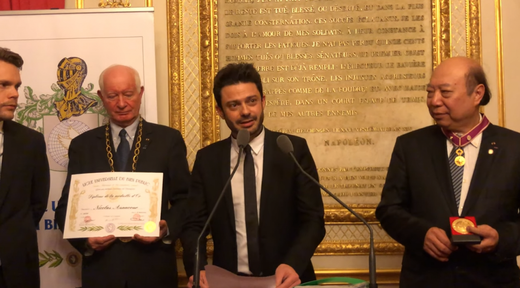 Le chanteur Grégory Bakian remet à Nicolas Aznavour une médaille au Sénat